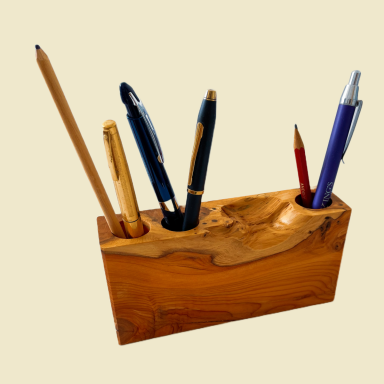 Wooden pen holder with various writing instruments including pens and a pencil.